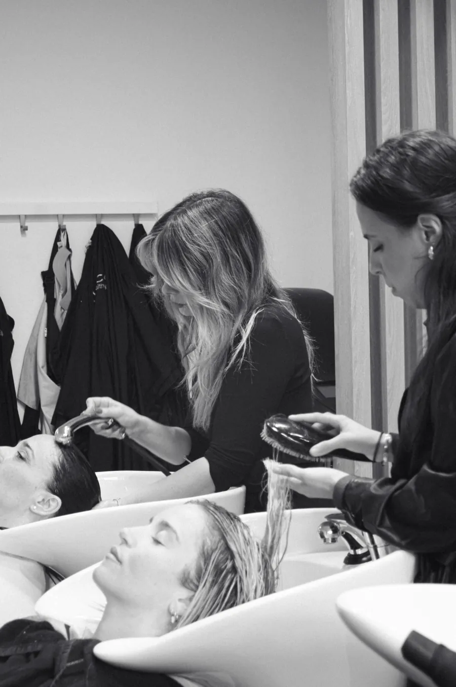 Stylistes autour d'une cliente dans le salon